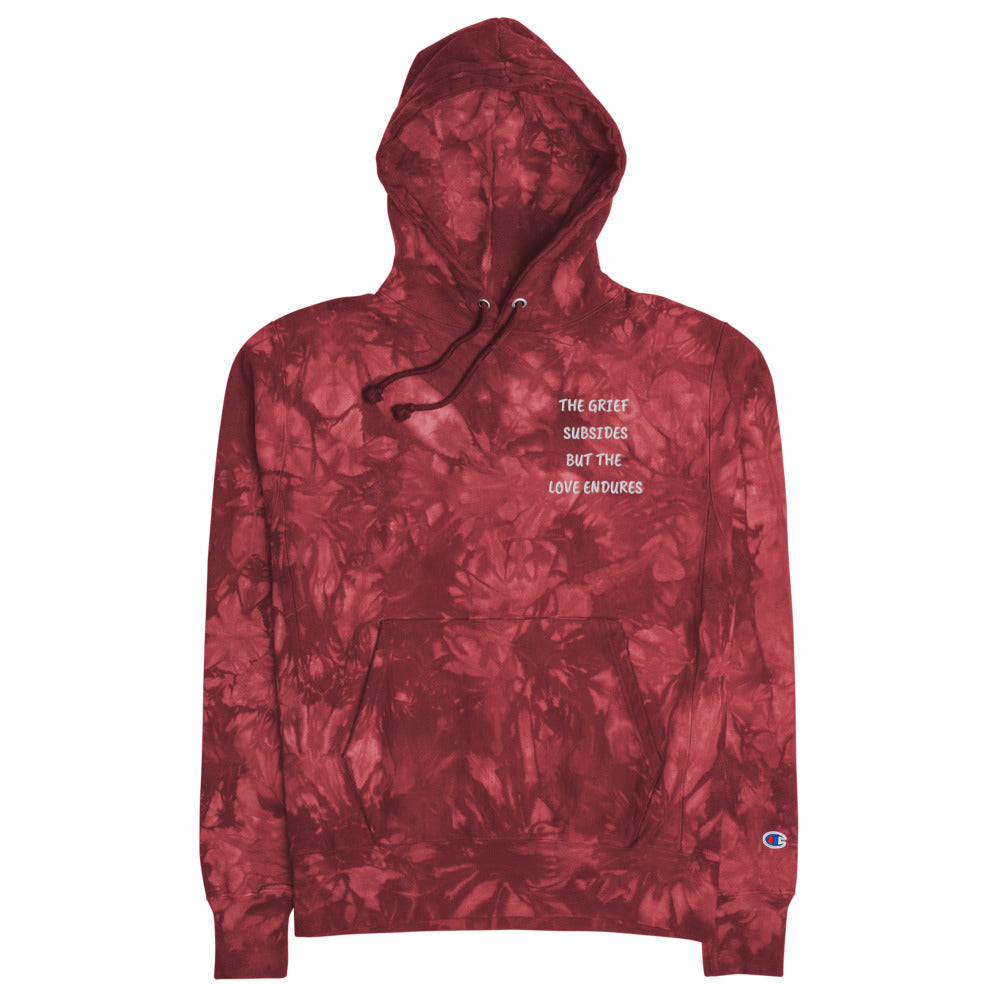 Unisex mulled berry Champion tie-dye hoodie. Embroidered quote, "The Grief Subsides But The Love Endures." Two-ply hood with matching drawcords, front pouch pocket, and embroidered "C" Champion logo on left sleeve. 1×1 rib knit side panels, sleeve cuffs, and bottom hem. Sizes small, medium, large, and extra large. JAMILLIAH'S WISDOM IS TIMELESS SHOP - wisdomistimeless.com.