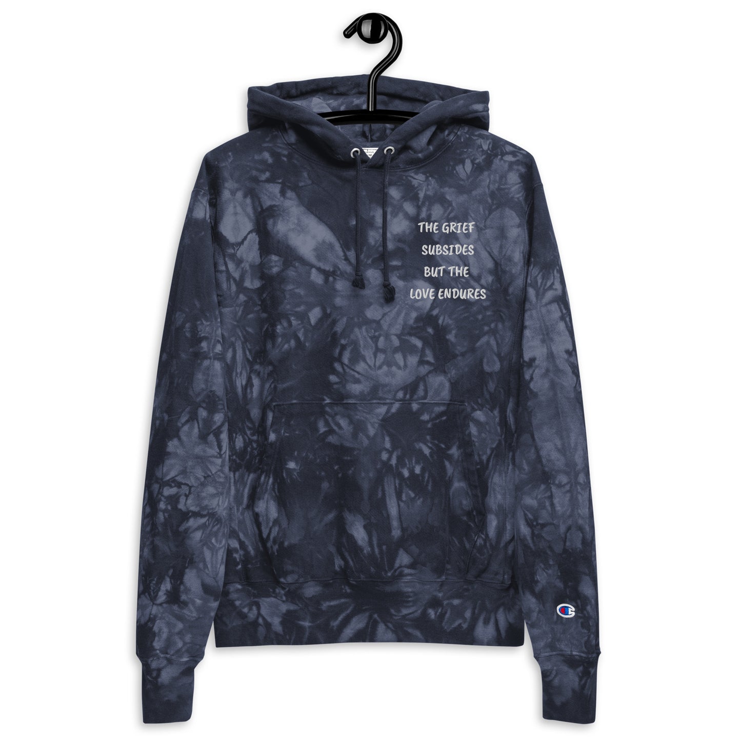 Unisex, navy colored Champion tie-dye hoodie. Embroidered quote, "The Grief Subsides But The Love Endures." Two-ply hood with matching drawcords, front pouch pocket, and embroidered "C" Champion logo on left sleeve. 1×1 rib knit side panels, sleeve cuffs, and bottom hem. Sizes small, medium, large, and extra large. 
