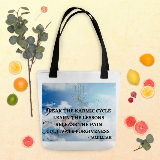All-over-print 15x15 tote bags with black straps, front. Clocks in the blue, clouded sky with hamsa hand/infinity sign logo, and unique wise quote mantra. "Break The Karmic Cycle, Learn The Lessons, Release The Pain, Cultivate Forgiveness." - Jamilliah - Shown flat with green leaves and sliced/whole limes, lemons, and oranges. JAMILLIAH'S WISDOM IS TIMELESS SHOP - wisdomistimeless.com.